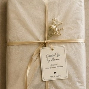 Artwork wrapped in tissue with ribbon, dried flowers and a tag